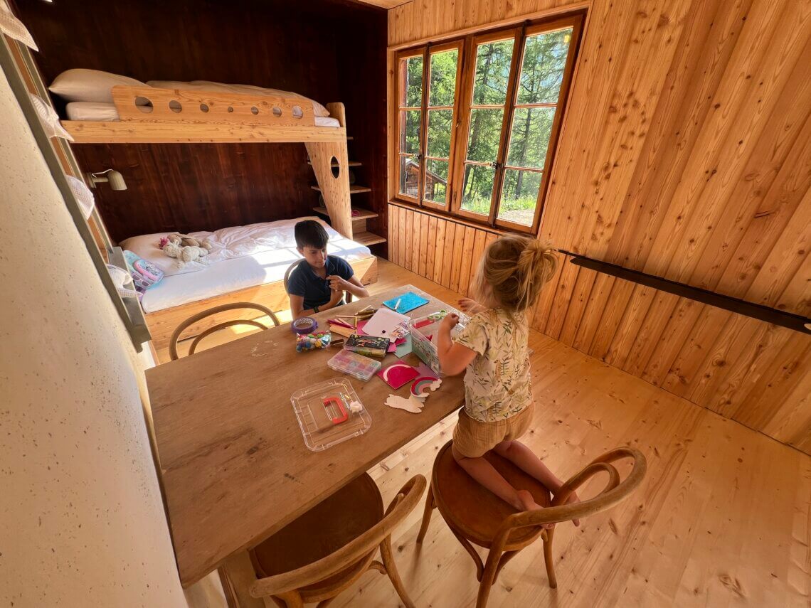 Een ruime familiekamer met stapelbed voor de kids en tafel.